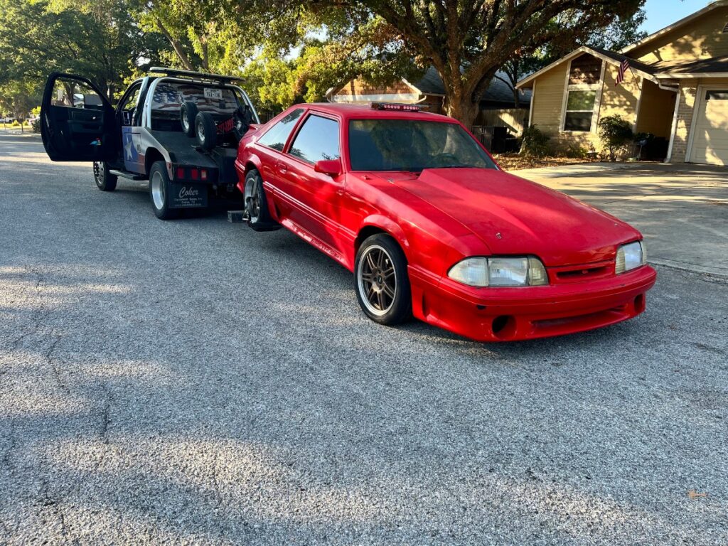 image of a red car being towed by the tow truck of Texas Patriot Towing