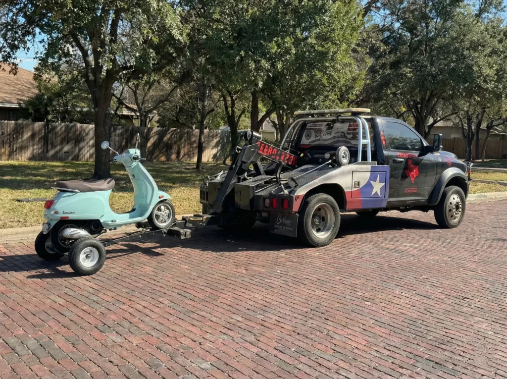 Image of a scooter being towed by texas patriot towing truck